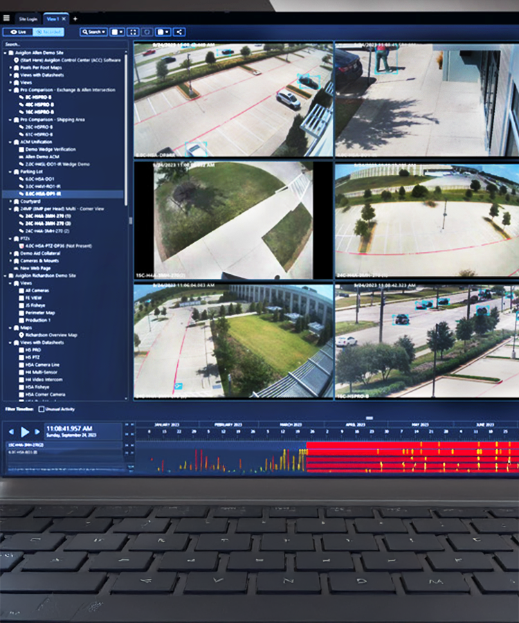 A laptop screen displays surveillance footage with five camera views of a parking lot and surrounding area. The interface includes a list of camera options on the left and a timeline with activity markers at the bottom.