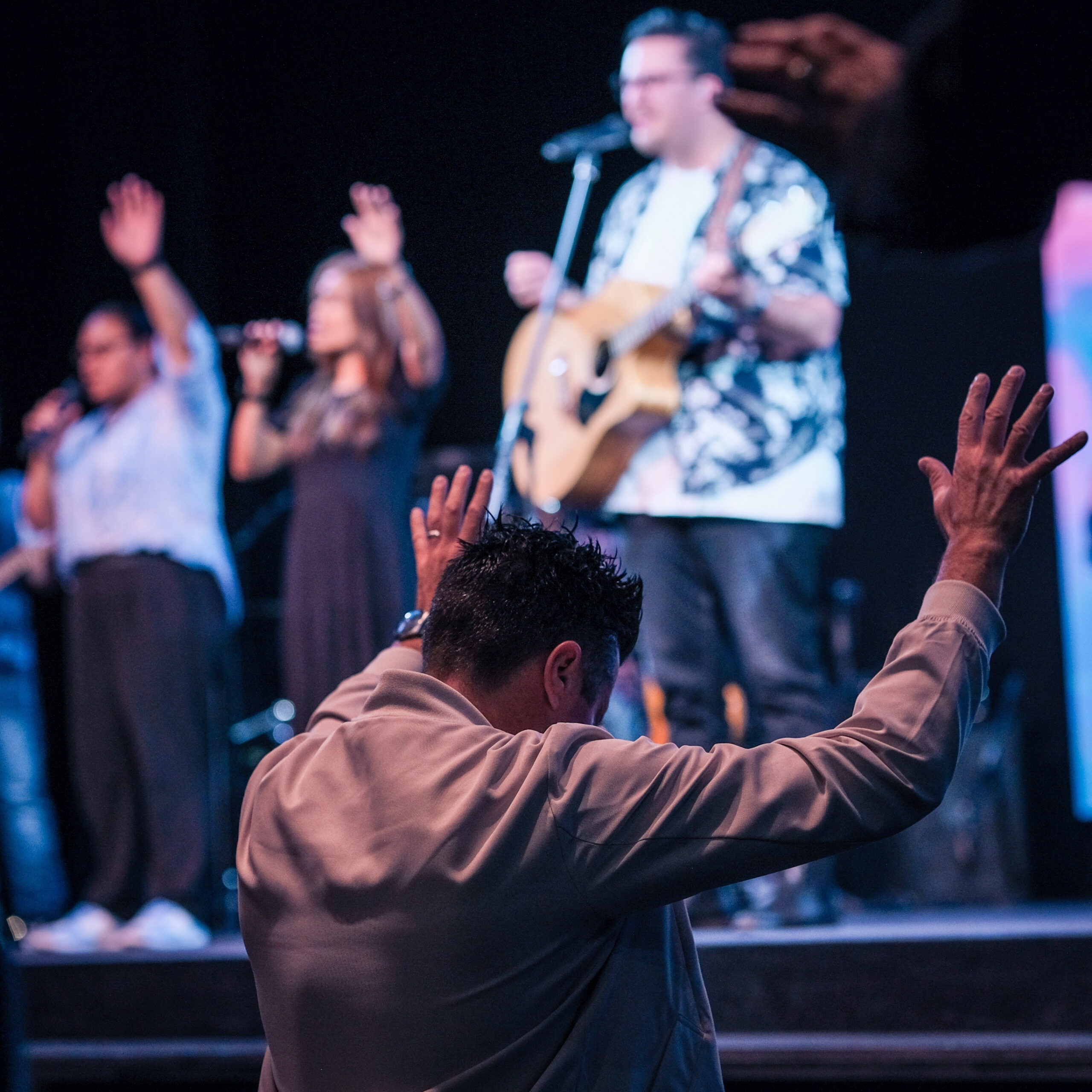 A,Man,Raises,His,Hands,In,Worship,During,A,Church